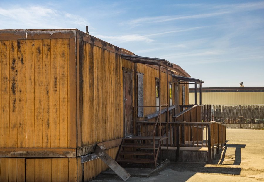 Storm-damaged single-wide manufactured home being cleared from a lot